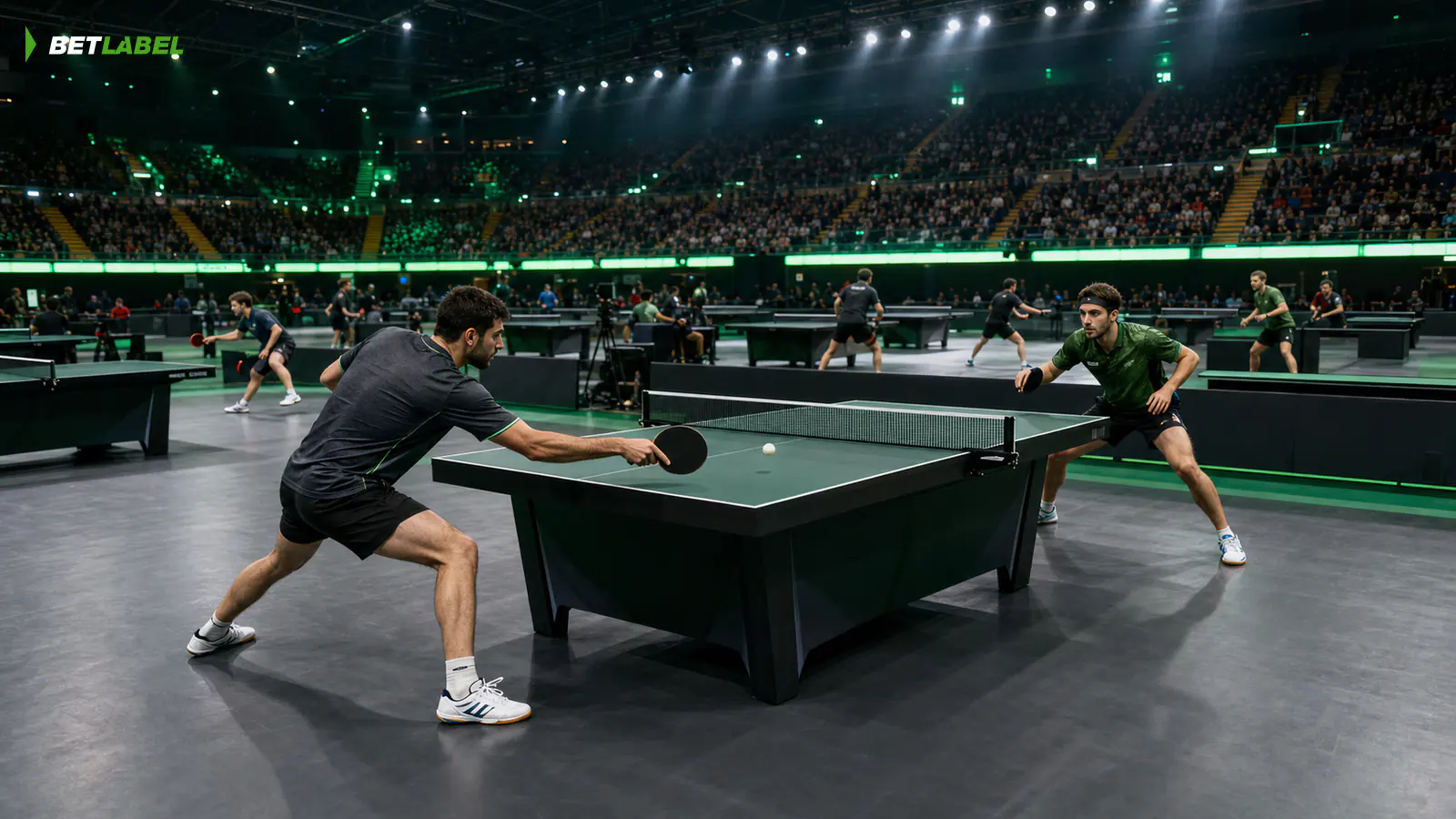 Due giocatori adulti di tennistavolo durante un torneo serale BetLabel